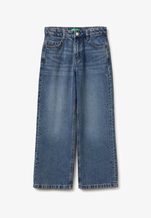 Niebieskie dżinsy z szerokimi nogawkami, zapinane na guziki, z przednimi i tylnymi kieszeniami oraz metalowymi przelotkami biegnącymi wzdłuż obu zewnętrznych boków.