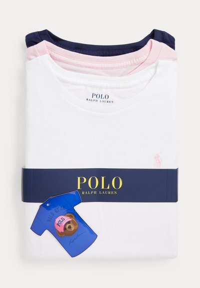 Drie gevouwen Polo Ralph Lauren t-shirts in marineblauw, roze en wit, gestapeld met een marineblauwe merkband en een blauw berenvormig label.