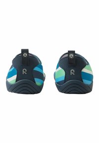 Zbliżenie na buty wsuwane z wielokolorowym, paskowanym wzorem w kolorze niebieskim, zielonym i białym, z teksturowaną gumową podeszwą i uchwytem.