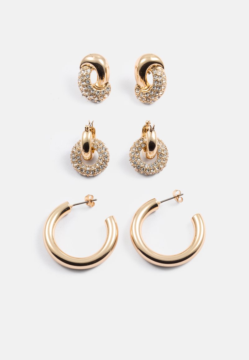 Três pares de brincos em tom de ouro: dois pares apresentam designs redondos com cristais, e um par tem uma forma circular lisa.