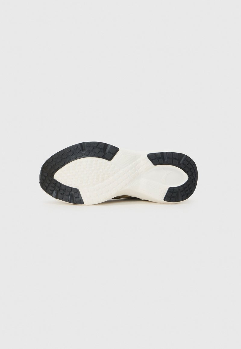 Suela de zapato deportivo con un patrón de goma negra texturizada, una entresuela de espuma EVA blanca y un diseño aerodinámico y ligero que ofrece tracción y soporte.