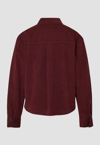 Camicia in corda a maniche lunghe di un profondo bordeaux con polsini abbottonati, una yoke posteriore e una piega centrale dietro.