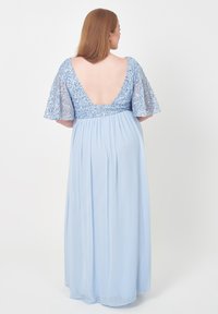 Ljusblå golvlång klänning med paljetterade korta ärmar och djup V-back, i mjukt, flödande tyg.