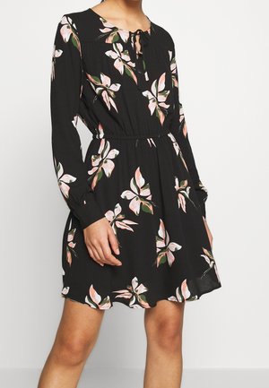 Robe noire à manches longues, motif floral rose et vert, taille cintrée, encolure ronde avec détail à nouer, tissu léger.