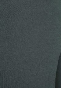 Donkergrijze gebreide stof met een gladde textuur, voorzien van een subtiel geribd patroon. De close-up toont de rekbaarheid en zachtheid van het materiaal.