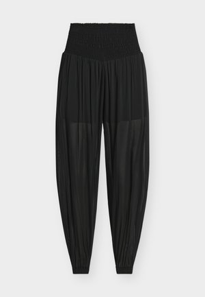 Pantalon noir taille haute transparent et ample, avec taille élastique et bas élastiqués, présenté sur un fond blanc uni.