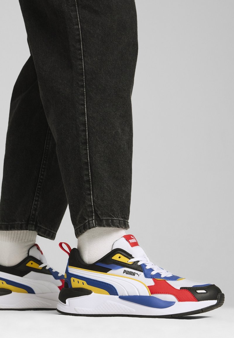 Baskets Puma présentant un mélange de noir, blanc, rouge, jaune et bleu. Tige en mesh texturé, col rembourré et semelle coussinée.