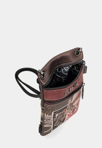 Braune Leder-Crossbody-Tasche mit grafischem Frontdesign, zwei mit Reißverschluss versehenen Fächern und verstellbarem Trageriemen. Das Innenfutter zeigt ein kontrastierendes schwarzes Muster.