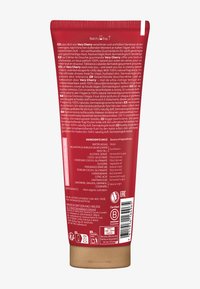 Tubo schiacciabile rosso contenente crema per doccia etichettata "Very Cherry". Ingredienti chiave e istruzioni stampati in più lingue sul retro.