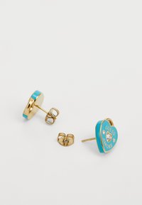 Boucles d'oreilles en forme de cœur en or avec émail turquoise, comportant le texte "GUESS AMORE" et un accent en pierre claire. Comprend des fermoirs assortis.