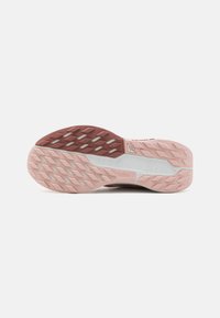 Semelle de chaussure de course légère avec un design en caoutchouc texturé rose et blanc, doté d'une texture à motifs pour une meilleure adhérence.