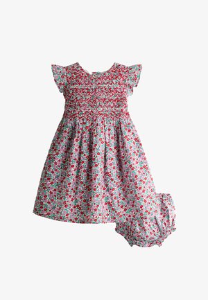 Virágos babaruha ráncolt felsőrésszel és hozzáillő buggyos nadrággal, piros, rózsaszín és zöld színekben, fehér háttéren.