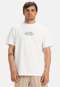 White cotton t-shirt featuring a blue graphic design with stars on the front. Short sleeves and a relaxed fit. No other distinct features noted.