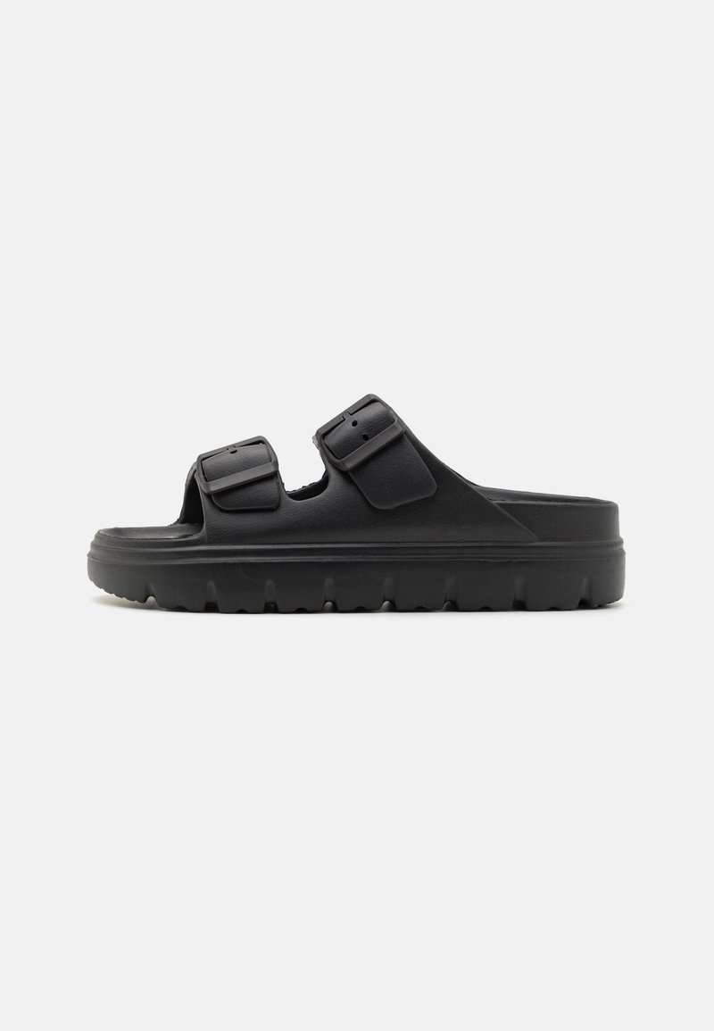 Black slide sandals made of rubber, featuring two adjustable buckles, a thick sole with grooves, and an open-toe design.