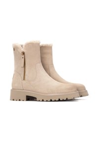 Botines de ante beige con un puño de piel sintética, cremallera lateral y suela de goma resistente con profundas marcas para mayor tracción.