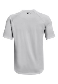 Camiseta atlética de manga corta en gris, confeccionada con una tela suave y ligera. Presenta un escote redondeado y un pequeño logo en la parte posterior. Diseño sencillo.