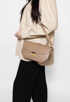 Borsa a tracolla in pelle beige con una forma strutturata, accessori in oro e patta pieghevole. La tracolla è regolabile per il trasporto crossbody.