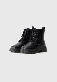 Black ankle boots made of leather with a lace-up front, side zipper, round toe, rugged sole, and dual pull tabs for easy wear.