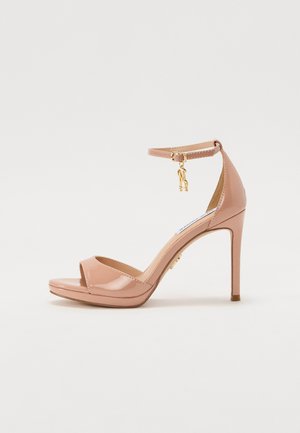 Patenteret pink højhælet sandal med ankelsløjfe og guldfarvet hardware. Åben tå-design og glat tekstur med en platformssål.