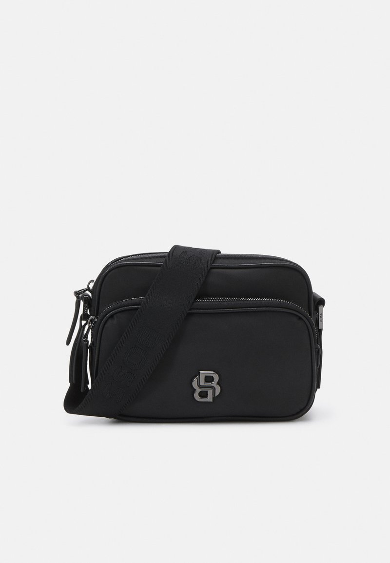 Borsa a tracolla nera realizzata in materiale morbido, con due scomparti con zip e una tracolla. Dettaglio del logo argentato sulla parte anteriore.