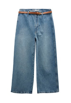 Brede denim jeans in lichtblauw, met een hoge taille en een bruine leren riem. Strakke lijnen met minimale stikdetails.