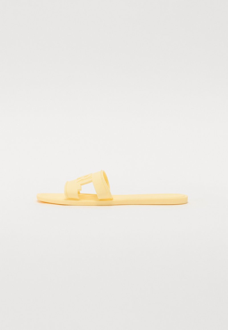 Yellow rubber sandal with two wide straps, open-toe design, flat sole, and textured bottom for grip. Simple, modern shape.