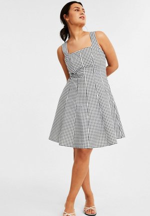 Schwarz-weißer kariierter Kleid mit rechteckigem Ausschnitt, breiten Trägern, enganliegendem Oberteil und schwingendem Rock, aus leichtem Stoff gefertigt.