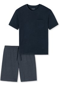 Camiseta de algodón azul marino de manga corta con bolsillo en el pecho, combinada con pantalones cortos azul marino con un patrón de lunares blancos y cintura ajustable.