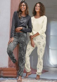 Two models wear long-sleeved tops and floral-patterned trousers. One top is dark gray, the other is light yellow. Trousers are gray and cream.