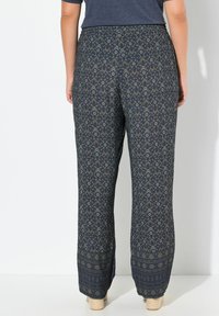 Navy-gepatenteerde broek met een ontspannen pasvorm, voorzien van ingewikkelde crèmekleurige geometrische ontwerpen en een elastische tailleband voor comfort.