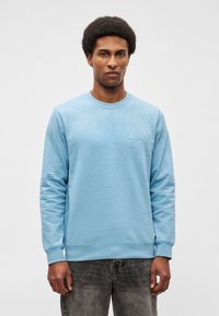 Sweatshirt azul claro com mangas longas e decote redondo. Apresenta um tecido texturizado e um pequeno logotipo retangular no peito.