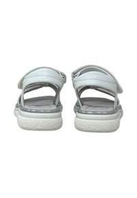 Sandali bianchi con cinturini regolabili, forma arrotondata, suola bianca texturizzata e accento iridescente lungo il plateau.