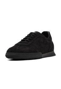 Sneaker in suede nero con texture liscia, punta arrotondata, lacci piatti e una suola in gomma discreta. Design minimalista senza branding visibile.