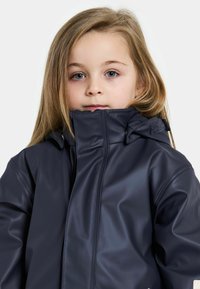 Marineblaue Regenjacke aus glattem, wasserdichtem Material mit hohem Kragen, Reißverschluss und verstellbarem Kapuze.