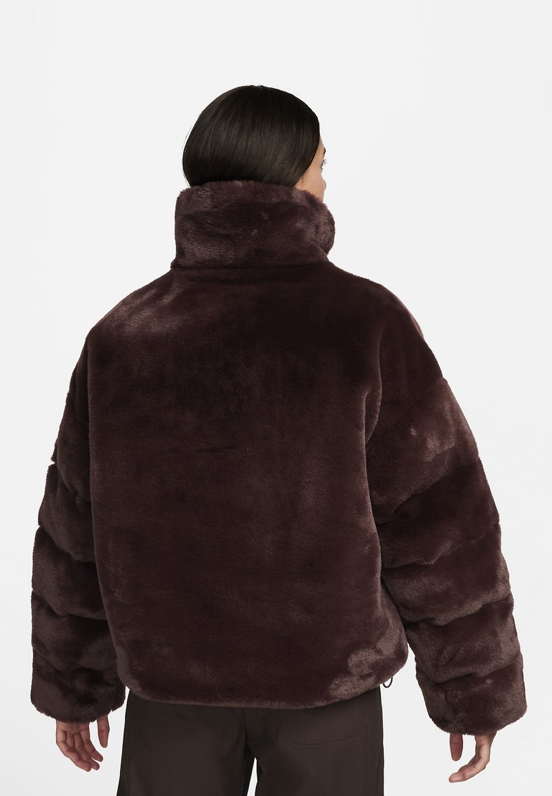 Giacca in finta pelliccia marrone con colletto alto, silhouette oversize e maniche testurizzate. Caratterizzata da una finitura morbida e pelosa e un fit rilassato.