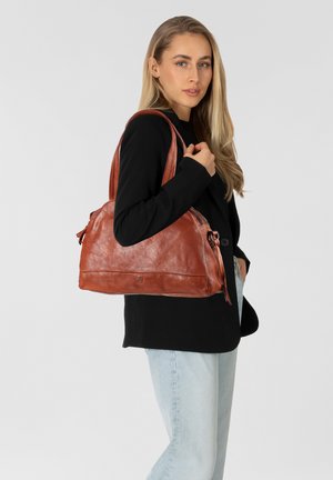 Leren handtas in een rijke roestbruin kleur. Beschikt over een gladde textuur, meerdere met rits afgesloten compartimenten en stevige schouderbanden.