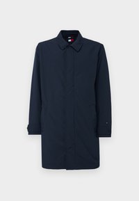 Heren lange donkerblauwe jas met knoopmanchetten, zijzakken en verborgen knopen aan de voorkant, weergegeven tegen een effen witte achtergrond.