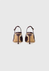 Crocodile-patterned, burgundy leather high-heeled slingback shoes with a pointed toe and a thin heel. Adjustable ankle strap with metal buckle.