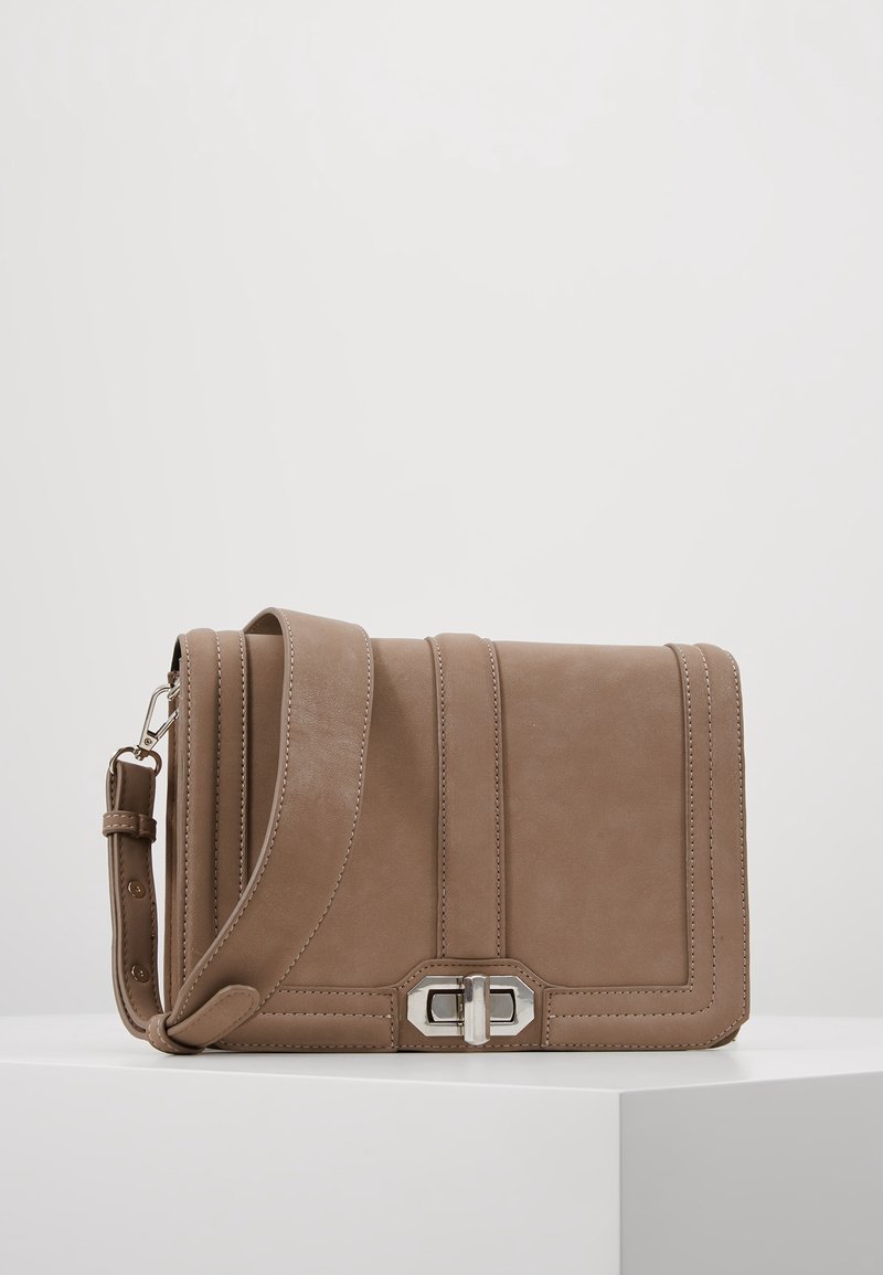 Brązowa skórzana torebka o gładkiej fakturze, z poziomym przeszyciem, metalowym zapięciem i regulowanym paskiem. Prostokątny kształt.