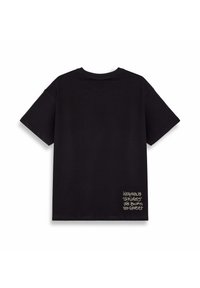 Camiseta de algodón negra de manga corta, con un escote redondo y texto en estilo graffiti blanco en la esquina inferior izquierda.