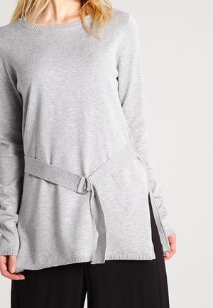 Pull en maille grise à manches longues, avec un col rond et une ceinture à nouer sur le côté. Doté d' ouvertures des deux côtés pour un style et un confort supplémentaires.