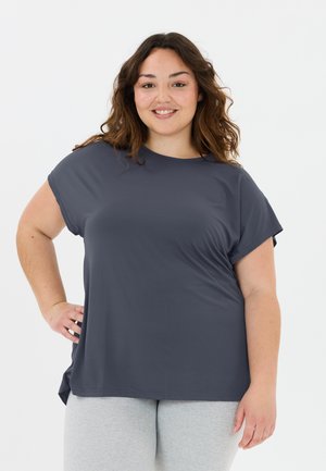 T-shirt court gris foncé à manches courtes avec un col rond, coupe décontractée et texture douce. Porté avec des leggings gris clair.