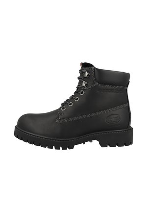 Bottine en cuir noir avec une semelle en caoutchouc robuste, des œillets en métal et des surpiqûres blanches contrastantes. Logo visible sur le côté.