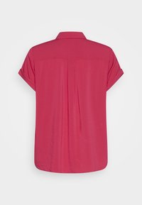 Short-sleeve, button-up shirt in bright pink. Features a collar, back pleat, and rounded hem. Smooth texture with no patterns or accents.