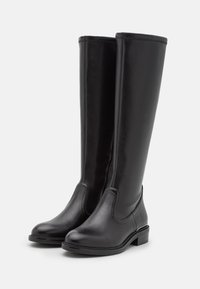 Bottes noires en cuir hautes jusqu'au genou, avec une texture lisse, un bout rond et un petit talon carré. Présentent des panneaux élastiques sur les côtés pour un enfilage facile.