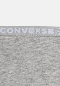 Γκρι βαμβακερό ύφασμα με υφή. Ένα ανοιχτό γκρι λογότυπο "CONVERSE" είναι εμφανώς τοποθ�ετημένο κατά μήκος της ζώνης.