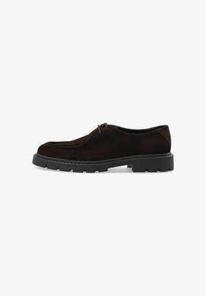 Chaussure en cuir suédé marron foncé à lacets, semelle épaisse en caoutchouc noir nervuré et couture détaillée le long du bord supérieur.
