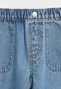Pantalones de mezclilla azul claro con una cinturilla elástica, que cuentan con bolsillos frontales y detalles de costura visibles. Tejido de alta calidad y texturizado.