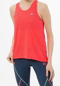 Top atlético de malla roja con escote redondo y un logo. Combinado con leggings azul marino que presentan acentos geométricos coloridos.