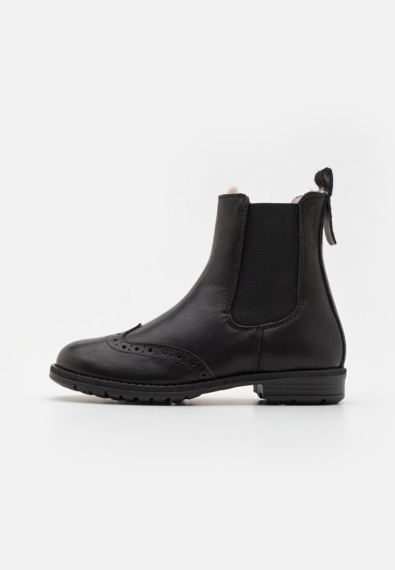 Botas Chelsea de cuero negro con paneles laterales elásticos, detalles de perforaciones, punta redondeada y una lengüeta en la parte trasera. Suela de goma texturizada.